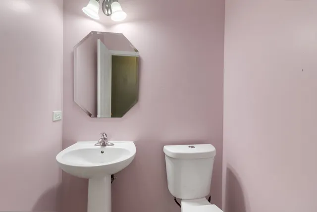 a bathroom with a toilet sink and mirror