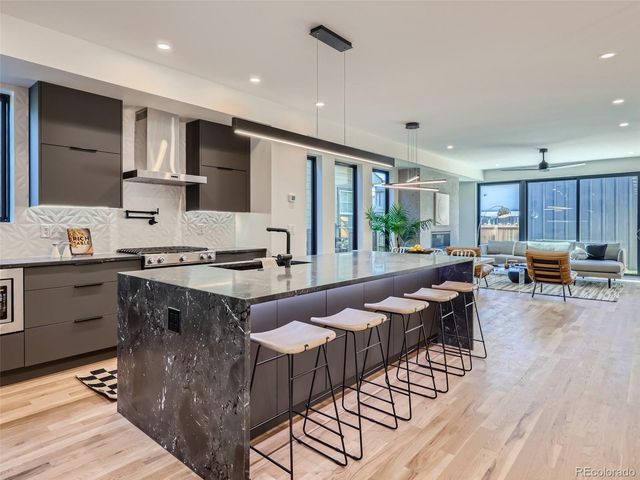 a open kitchen with stainless steel appliances granite countertop a stove and a refrigerator