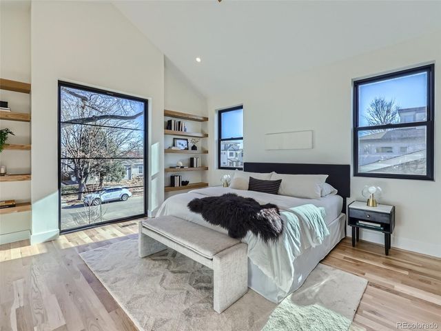 a spacious bedroom with a bed a window and painting on the wall