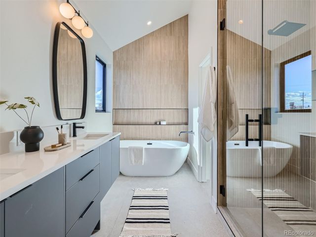a bathroom with a double vanity sink mirror and bathtub