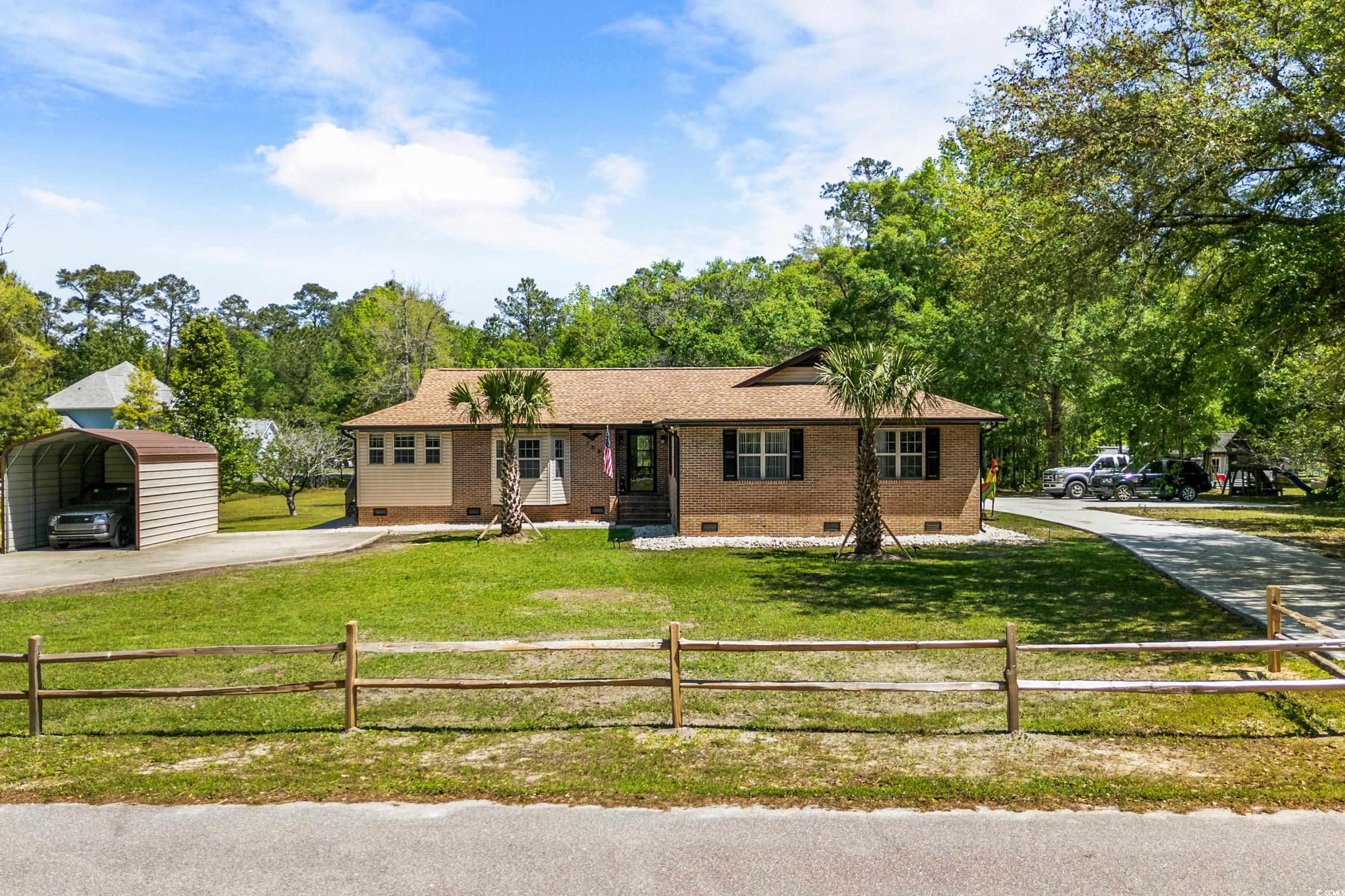 Single story home featuring a carport, crawl space, a front yard, and a fenced front yard