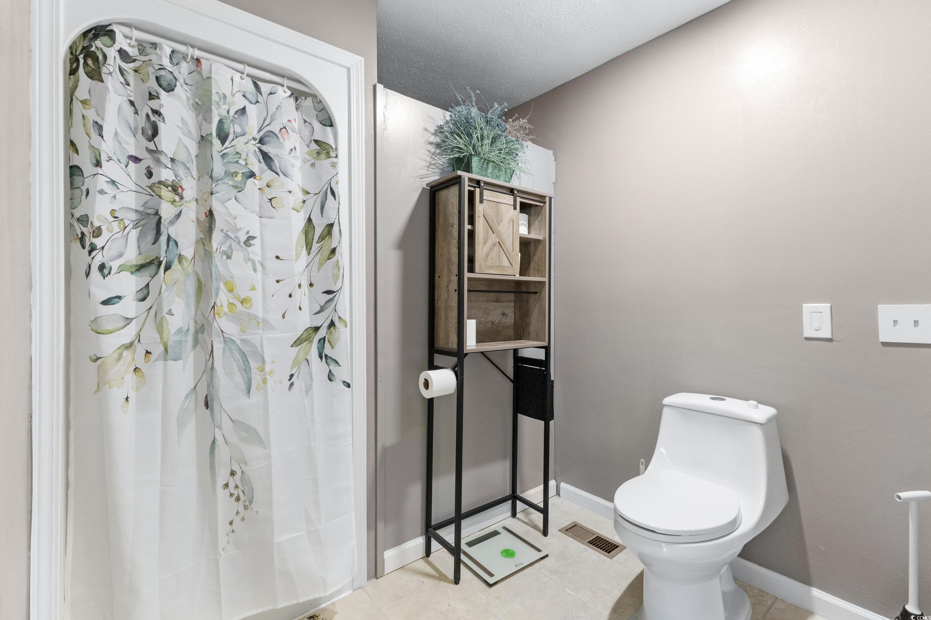 1869 Meadowood Lane Longs, SC 29568 - Photo 18 of 37 Bathroom with toilet, curtained shower, visible vents, and baseboards