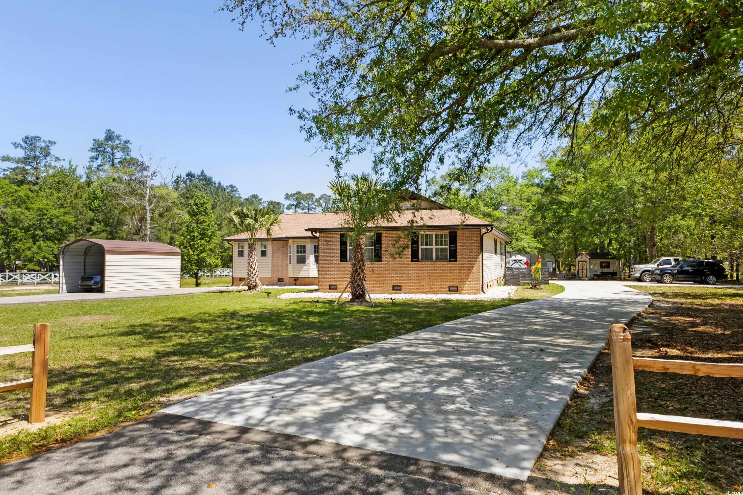 1869 Meadowood Lane Longs, SC 29568 - Photo 34 of 37 View of front of house with crawl space, concrete driveway, a front yard, brick siding, and a detached carport