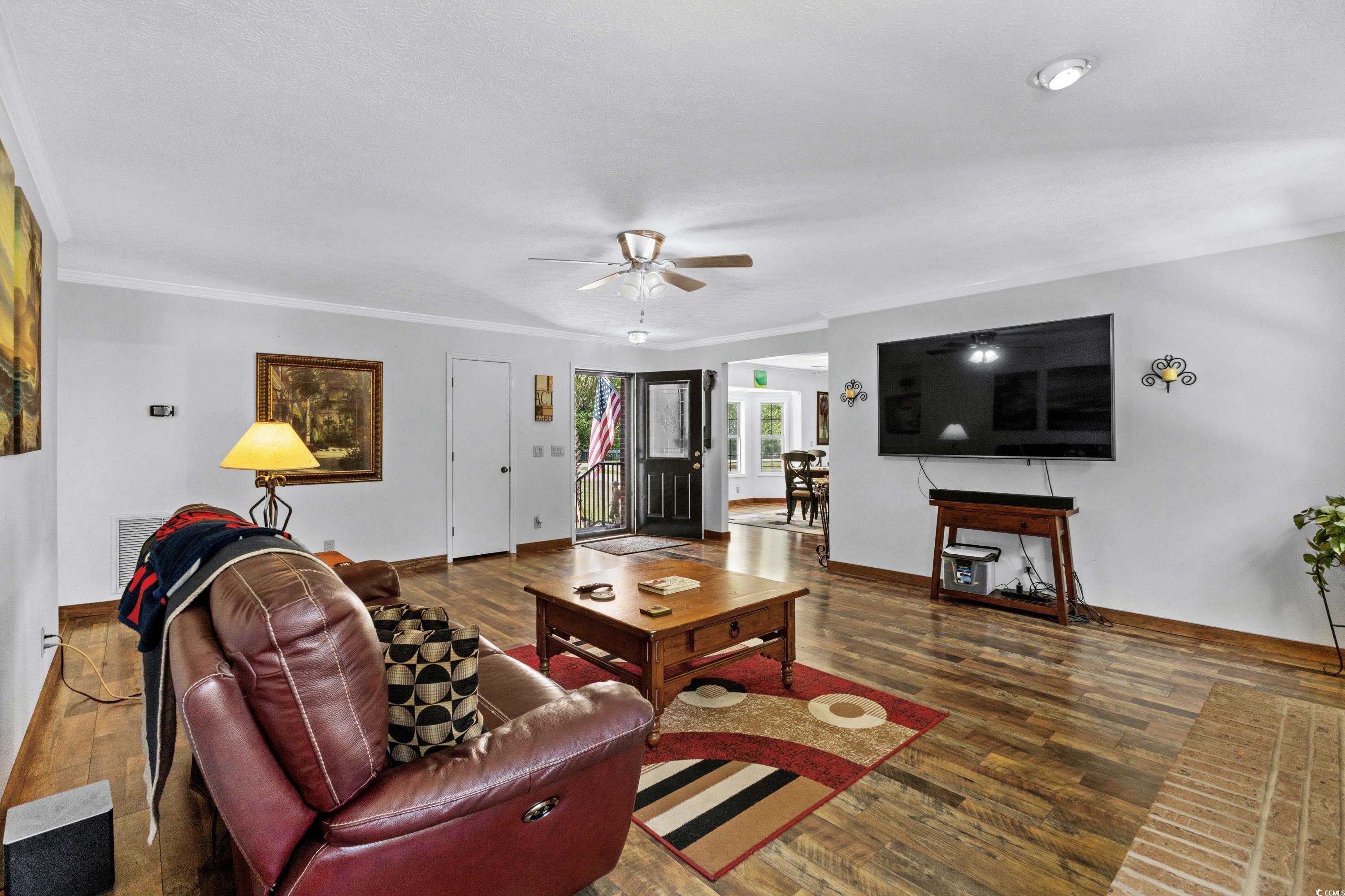 1869 Meadowood Lane Longs, SC 29568 - Photo 5 of 37 Living room featuring baseboards, wood finished floors, ornamental molding, and ceiling fan