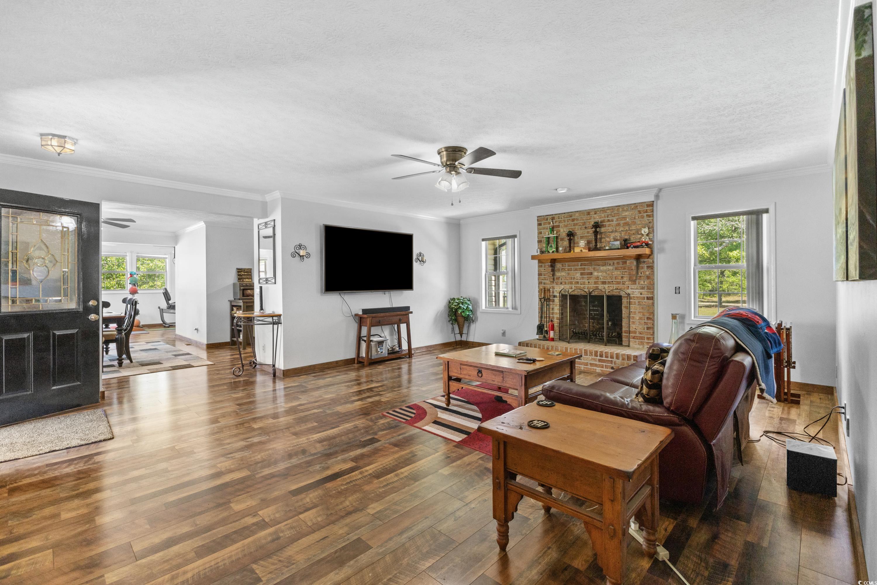 1869 Meadowood Lane Longs, SC 29568 - Photo 6 of 37 Living area with ceiling fan, ornamental molding, wood finished floors, and plenty of natural light