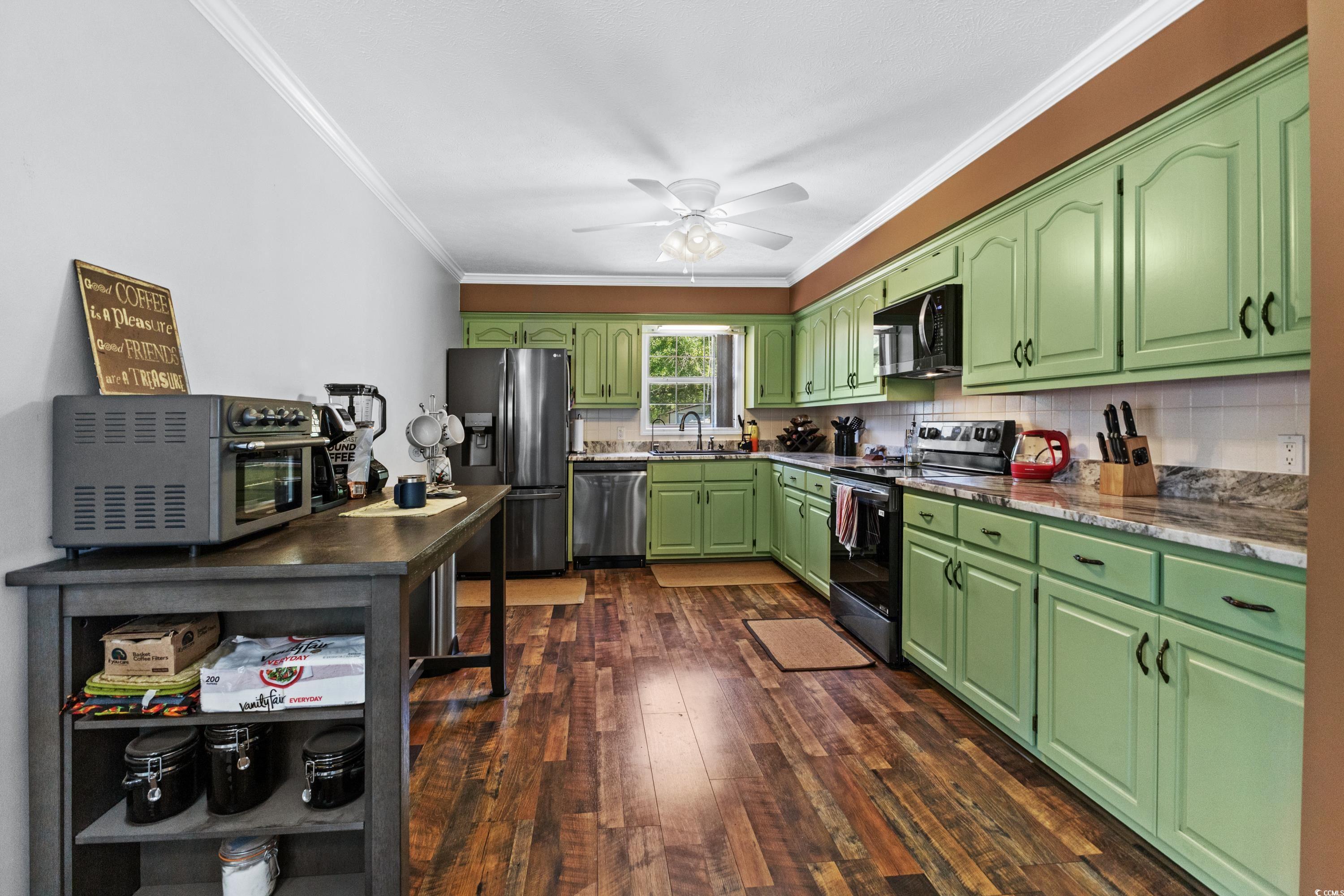 1869 Meadowood Lane Longs, SC 29568 - Photo 7 of 37 Kitchen with a ceiling fan, crown molding, a sink, stainless steel appliances, and dark wood finished floors