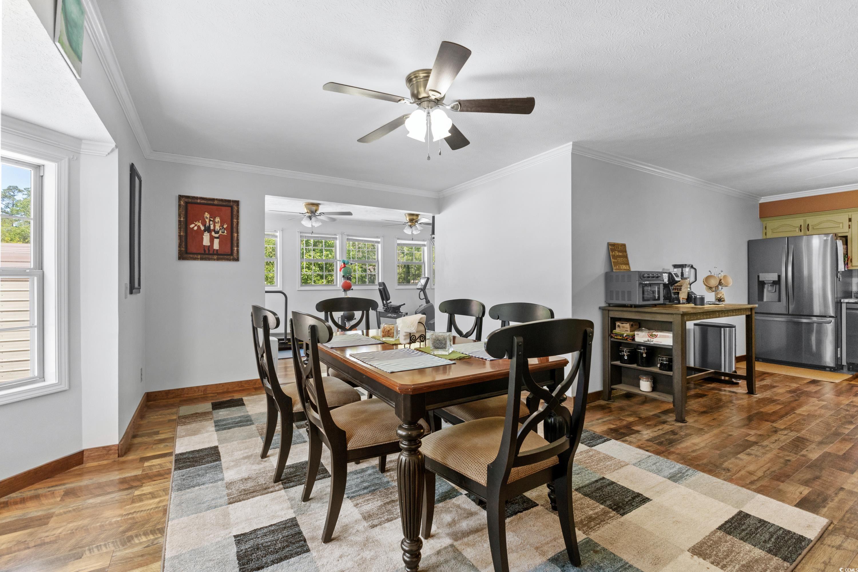 1869 Meadowood Lane Longs, SC 29568 - Photo 10 of 37 Dining room with light wood finished floors, a ceiling fan, baseboards, and ornamental molding