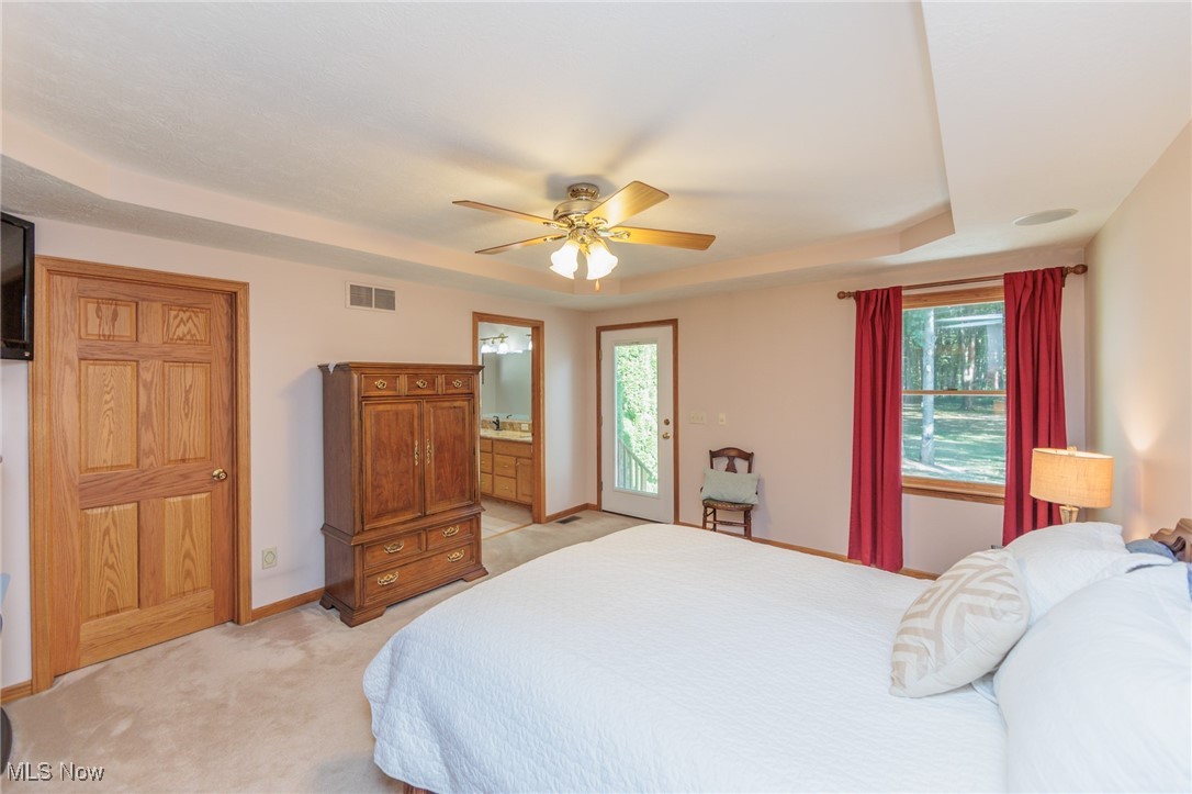 36556 Mills Road Avon, OH 44011 - Photo 24 of 36 Carpeted bedroom featuring ceiling fan, ensuite bath, a tray ceiling, and multiple windows