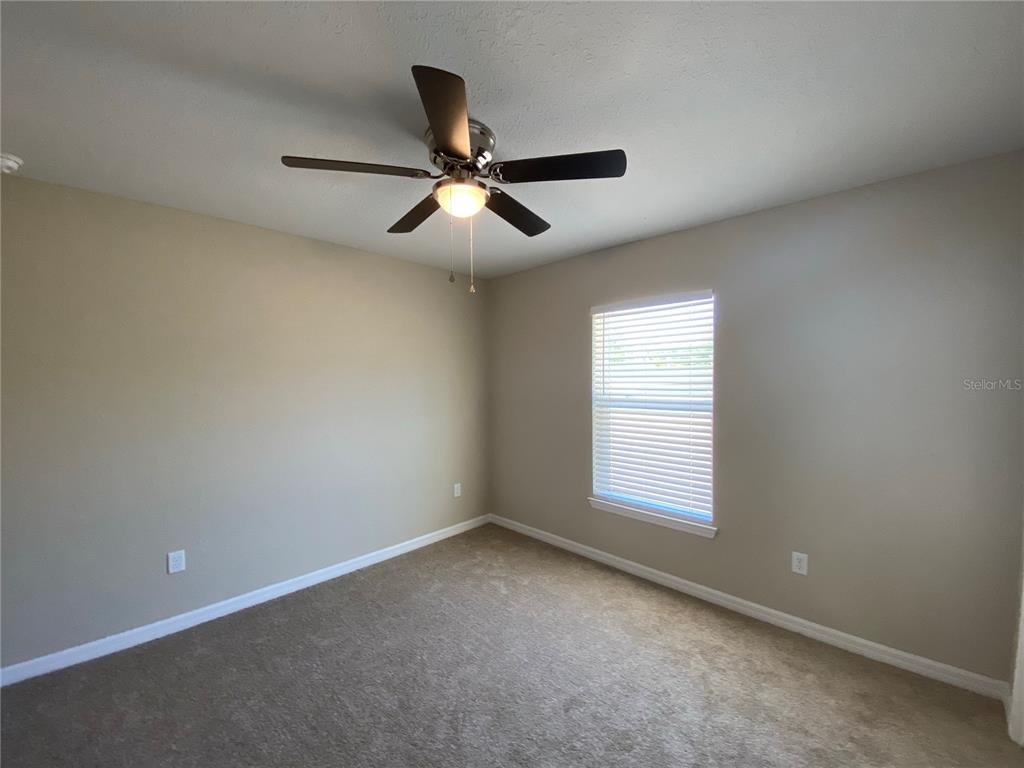 16767 Southwest 21st Terrace Road Ocala, FL 34473 - Photo 12 of 30 an empty room with a window and a ceiling fan