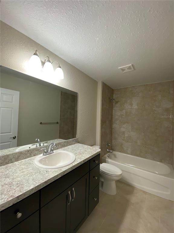 16767 Southwest 21st Terrace Road Ocala, FL 34473 - Photo 13 of 30 a bathroom with a granite countertop sink a toilet and a large mirror