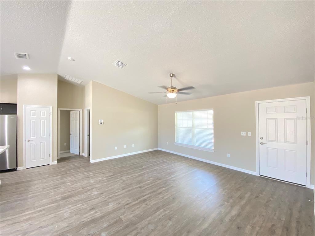 16767 Southwest 21st Terrace Road Ocala, FL 34473 - Photo 2 of 30 an empty room with wooden floor and windows
