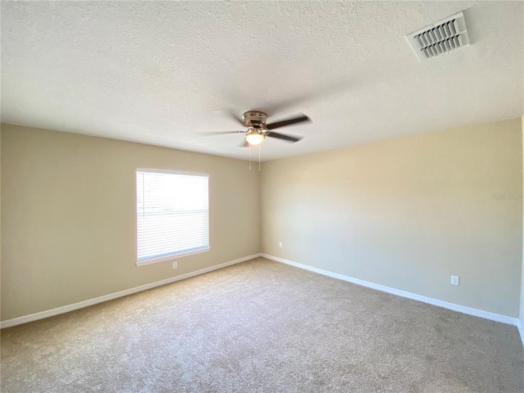 16767 Southwest 21st Terrace Road Ocala, FL 34473 - Photo 25 of 30 an empty room with a window and a ceiling fan
