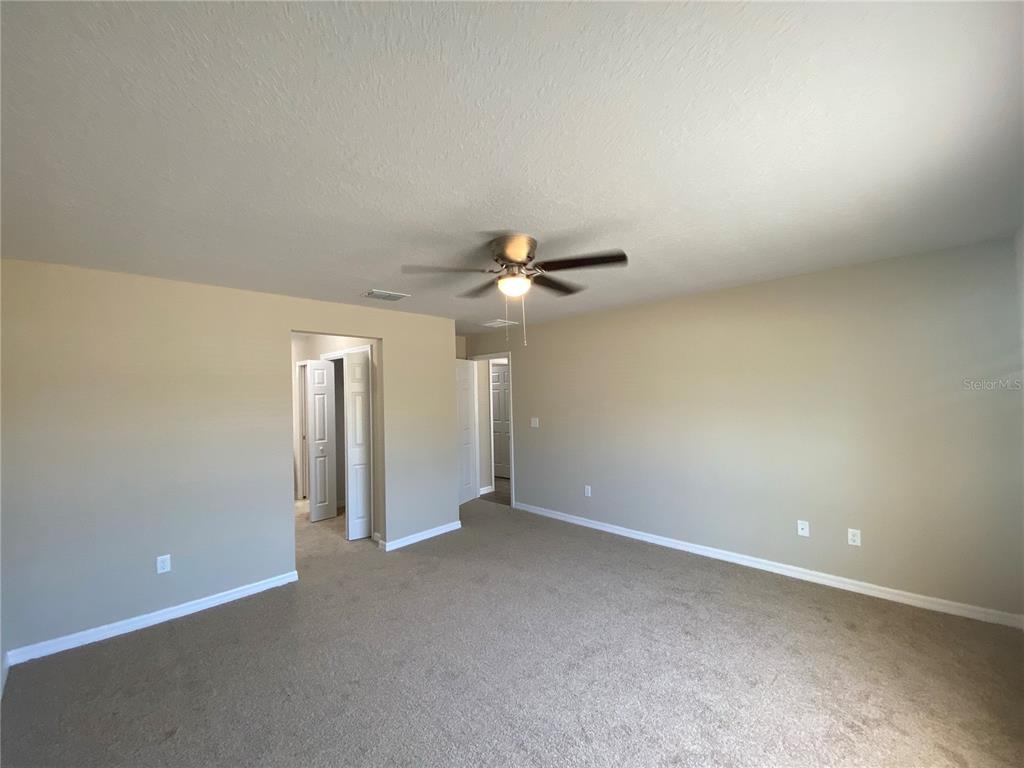 16767 Southwest 21st Terrace Road Ocala, FL 34473 - Photo 26 of 30 an empty room with closet and a chandelier fan