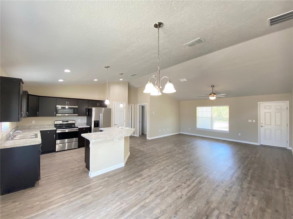 16767 Southwest 21st Terrace Road Ocala, FL 34473 - Photo 4 of 30 a view of a kitchen with a sink a microwave and cabinets