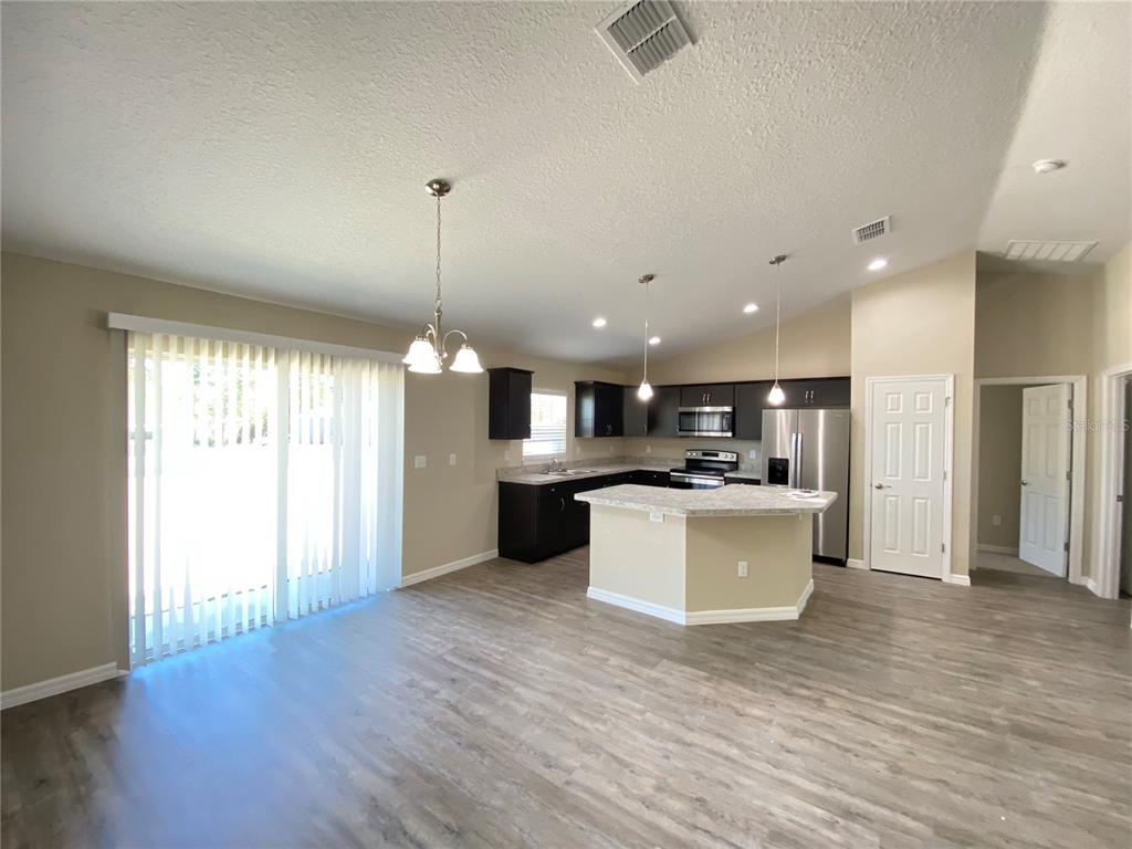 16767 Southwest 21st Terrace Road Ocala, FL 34473 - Photo 5 of 30 a large kitchen with a large counter top a sink stainless steel appliances and cabinets