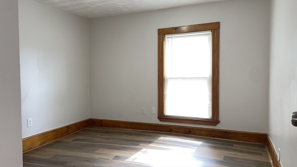 13 Whitman Street, Unit B Boston, MA 02124 - Photo 12 of 25 a view of empty room with wooden floor and fan
