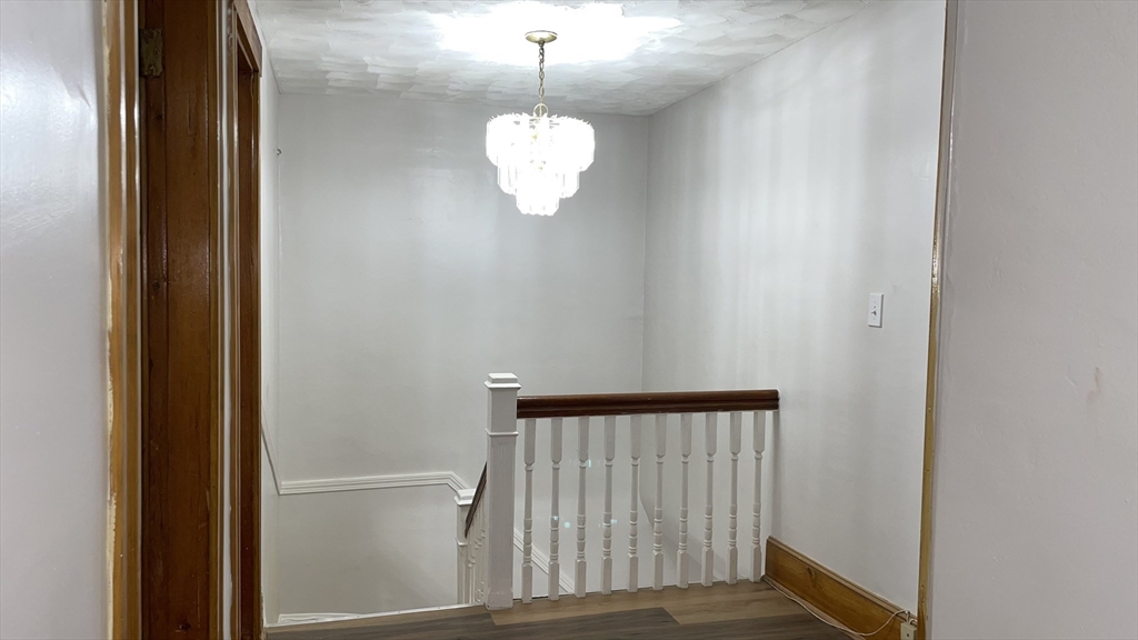 13 Whitman Street, Unit B Boston, MA 02124 - Photo 14 of 25 a view of a room with a hanging light and wooden floor
