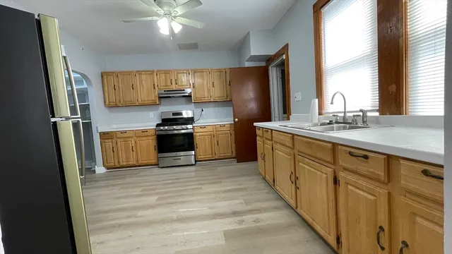 a kitchen with stainless steel appliances granite countertop a sink stove and refrigerator