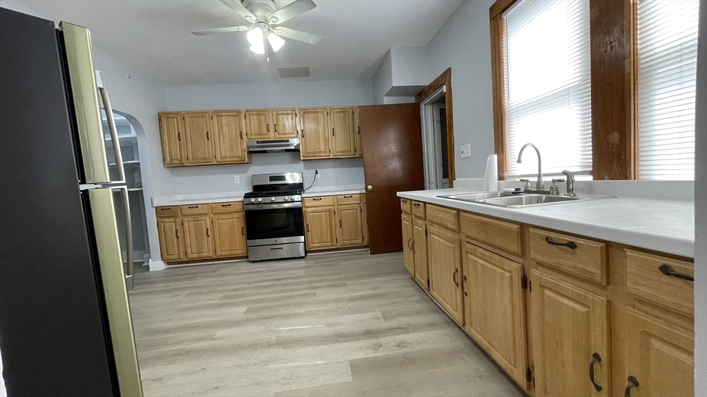 13 Whitman Street, Unit B Boston, MA 02124 - Photo 17 of 25 a kitchen with stainless steel appliances granite countertop a sink stove and refrigerator