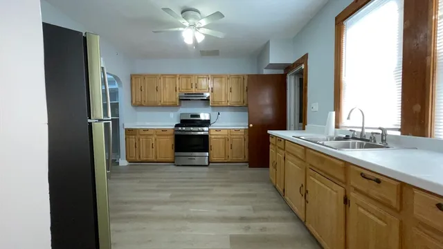 a kitchen with stainless steel appliances a sink and a refrigerator