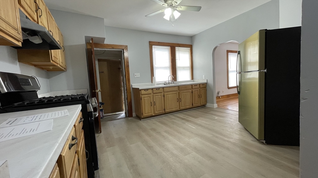 13 Whitman Street, Unit B Boston, MA 02124 - Photo 19 of 25 a kitchen with stainless steel appliances hardwood floor sink stove and refrigerator