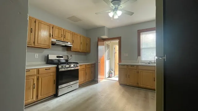 a kitchen with stainless steel appliances granite countertop a stove a sink and a refrigerator