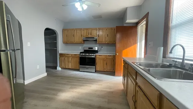 a kitchen with stainless steel appliances granite countertop a sink stove and refrigerator