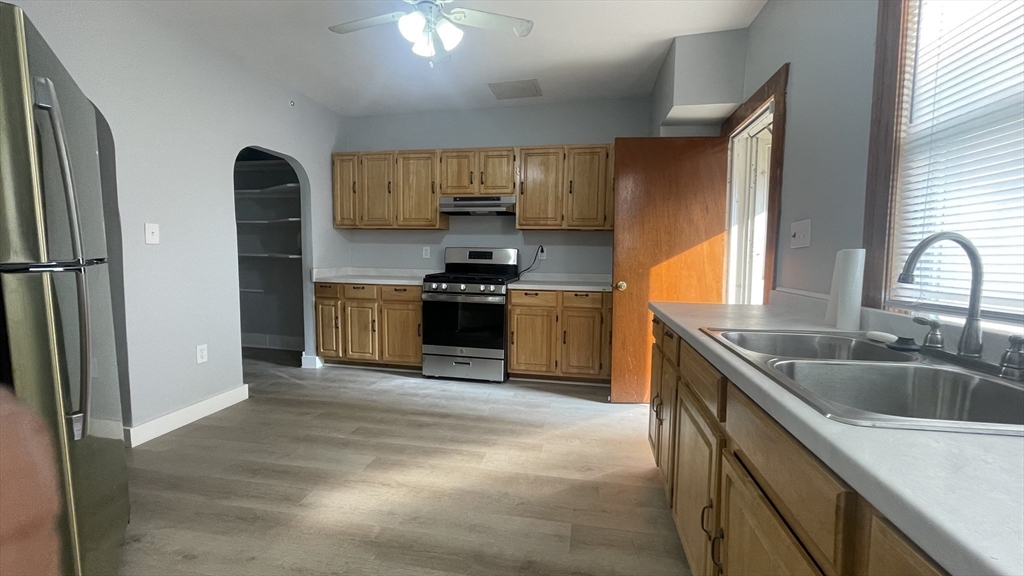 13 Whitman Street, Unit B Boston, MA 02124 - Photo 21 of 25 a kitchen with stainless steel appliances granite countertop a sink stove and refrigerator