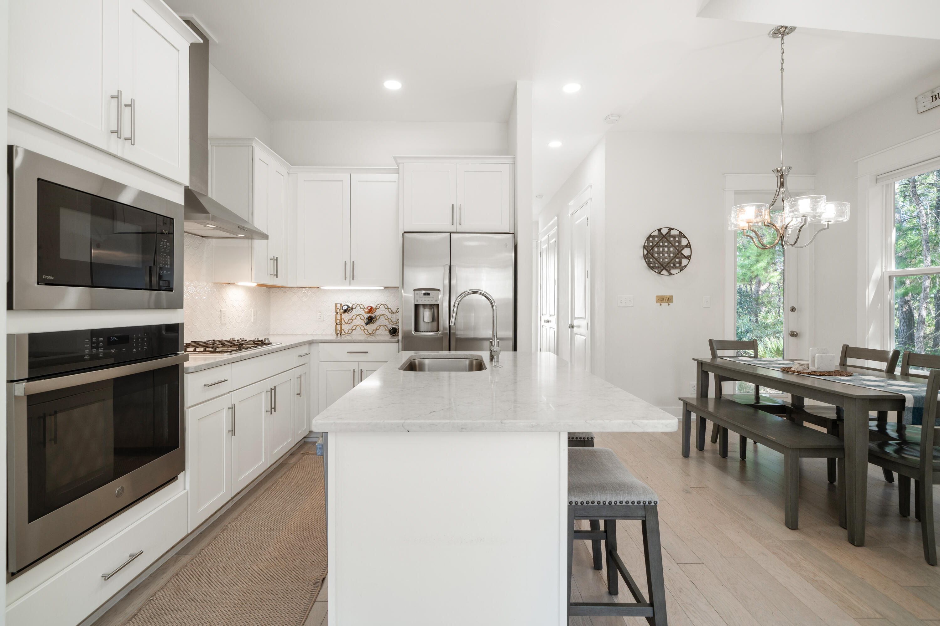 97 Beach View Drive Inlet Beach, FL 32461 - Photo 6 of 57 a kitchen with stainless steel appliances kitchen island granite countertop a stove a sink a microwave a dining table and chairs