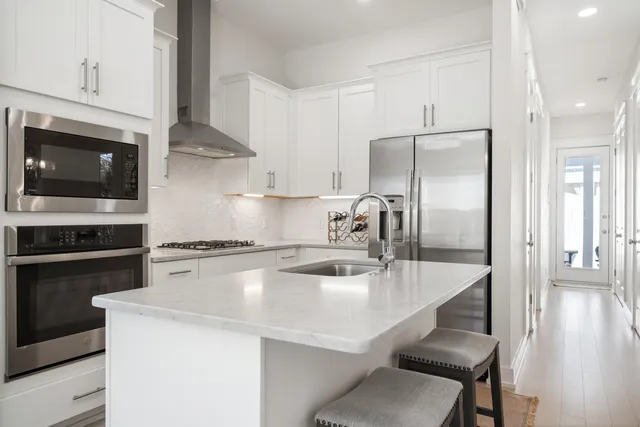 a kitchen with a sink a microwave a refrigerator and cabinets