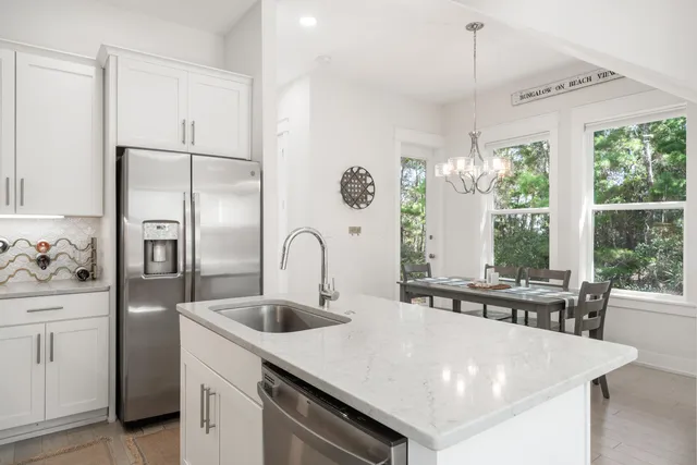 a kitchen with stainless steel appliances granite countertop a sink a stove and a refrigerator