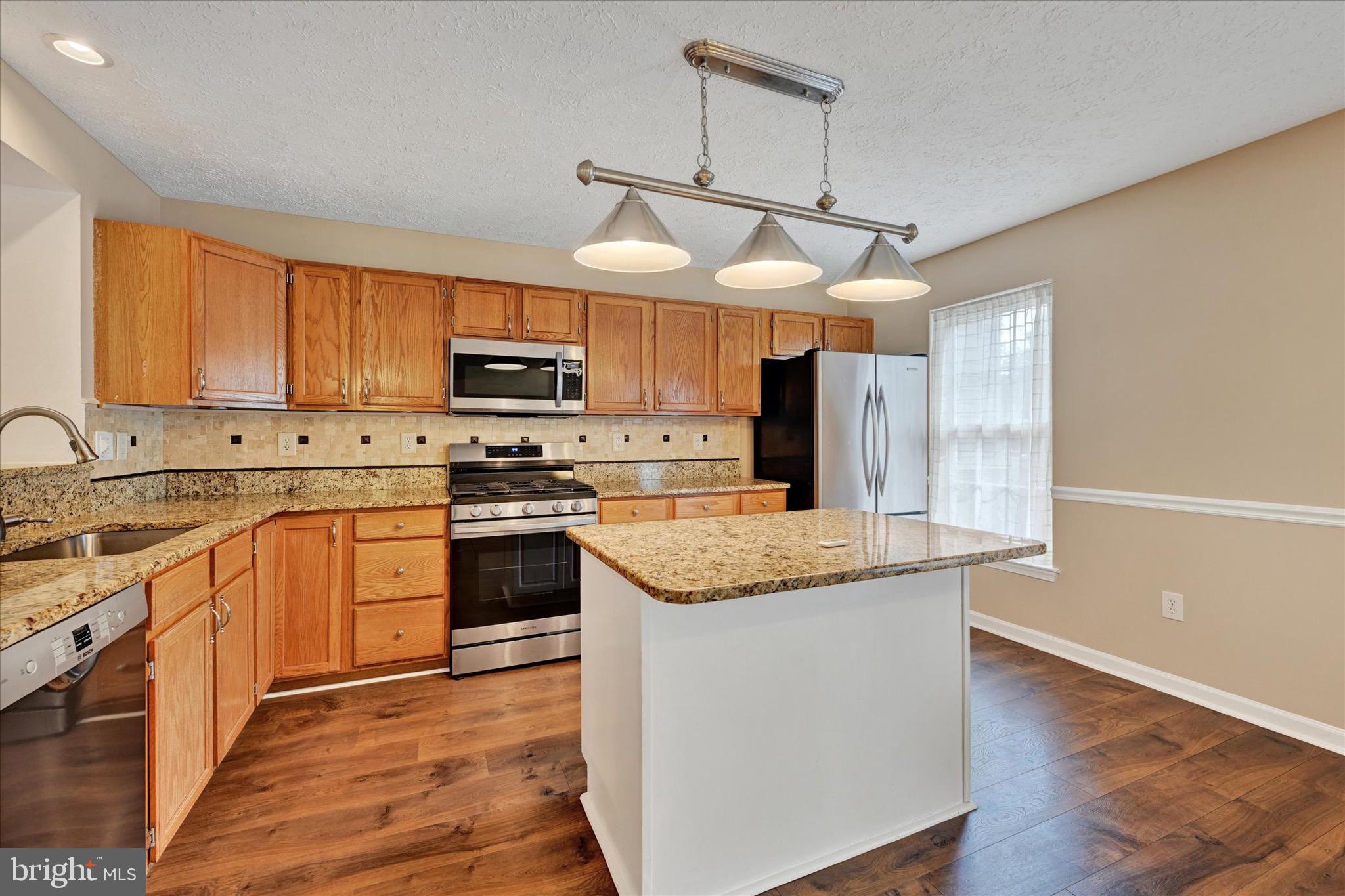 6119 Starburn Path Columbia, MD 21045 - Photo 11 of 28 a kitchen with stainless steel appliances granite countertop a stove a sink and a microwave