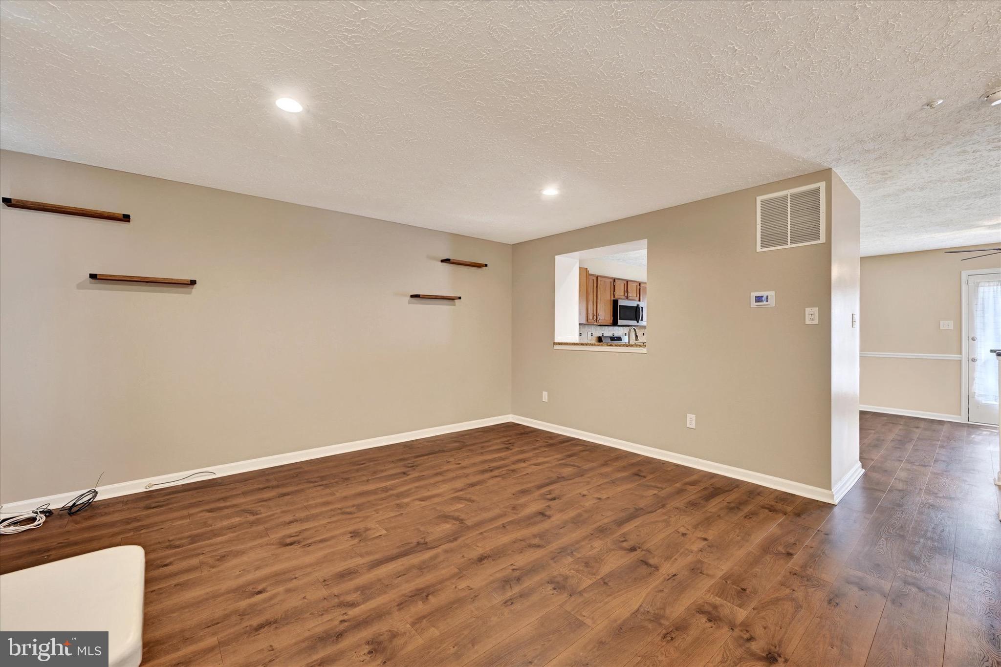 6119 Starburn Path Columbia, MD 21045 - Photo 2 of 28 an empty room with wooden floor and windows