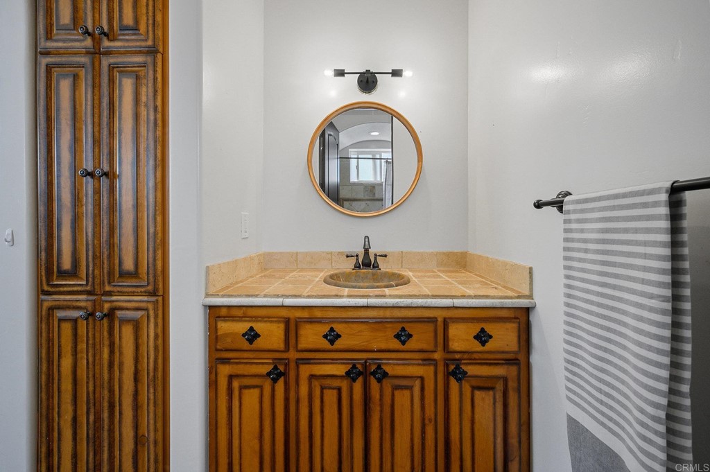 3209 James Drive Carlsbad, CA 92008 - Photo 35 of 65 a bathroom with a granite countertop sink and a mirror