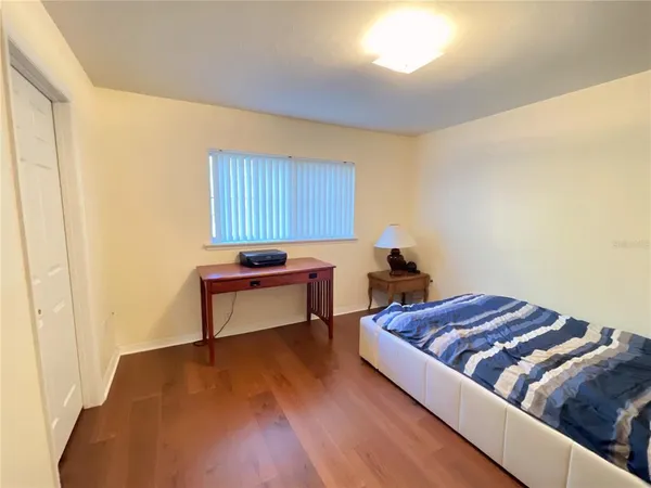 a living room with a bed and a dresser with wooden floor