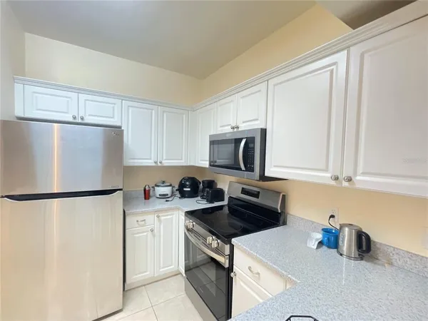 a kitchen with a refrigerator a stove a sink and cabinets