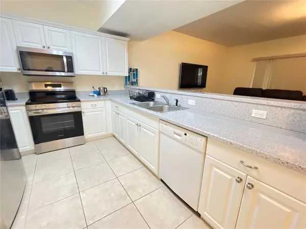 a kitchen with stainless steel appliances granite countertop a sink and a stove