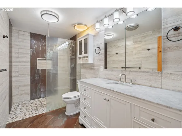 a bathroom with a sink a toilet and shower