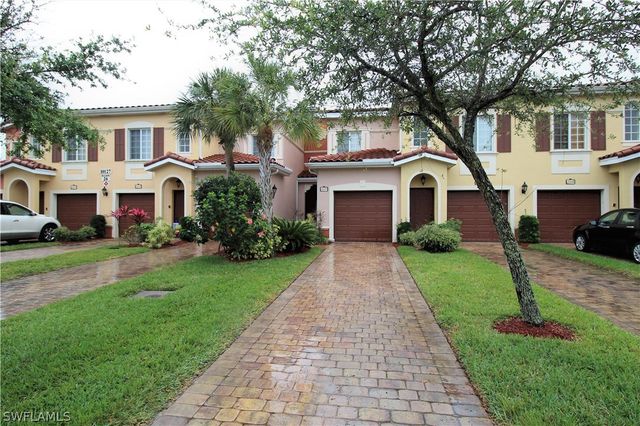 a front view of a house with a garden and trees