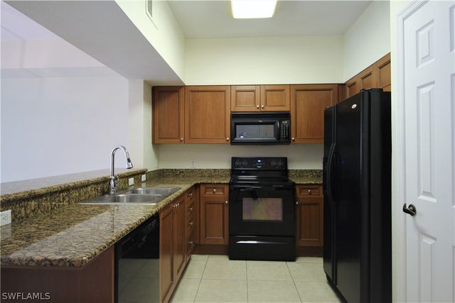 a kitchen with stainless steel appliances granite countertop a refrigerator stove and sink