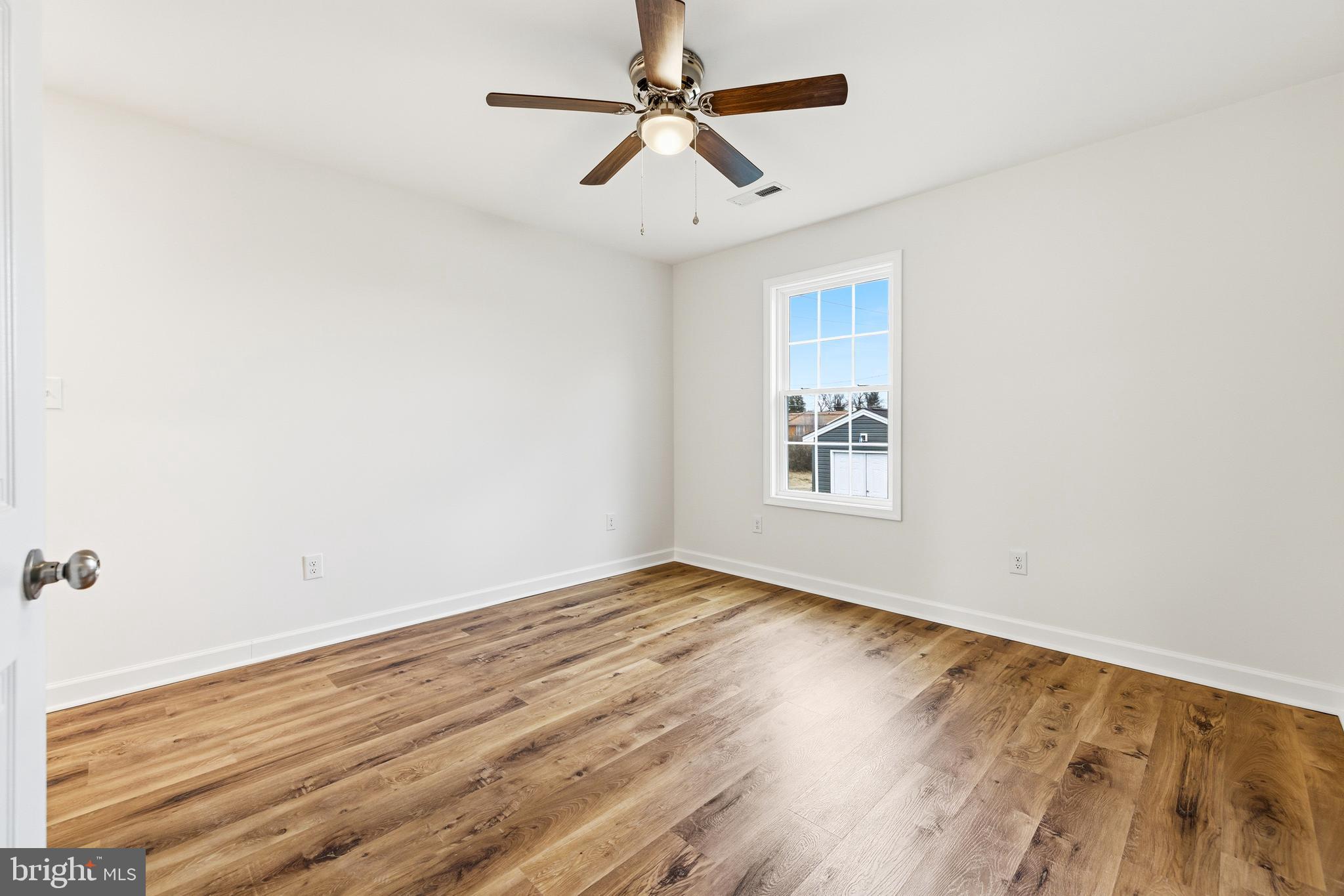 103 6th Avenue Luray, VA 22835 - Photo 19 of 58 an empty room with wooden floor ceiling fan and windows