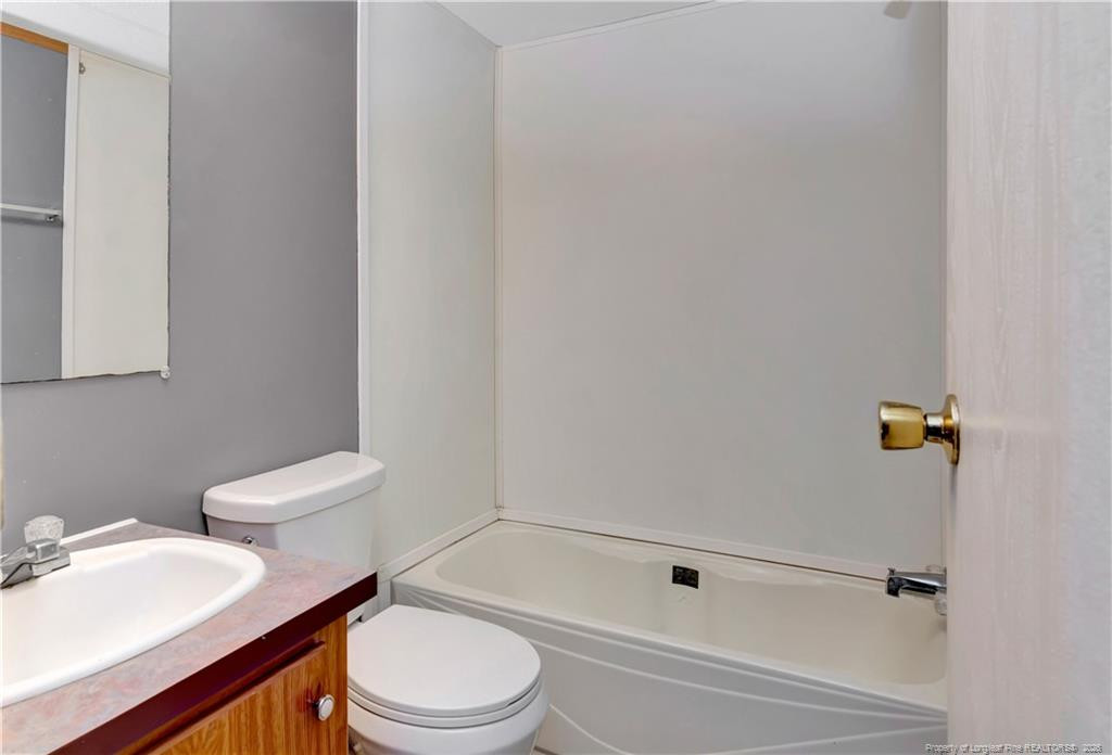 6459 Wire Grass Road Orrum, NC 28369 - Photo 16 of 22 a white toilet sitting next to a bathroom sink