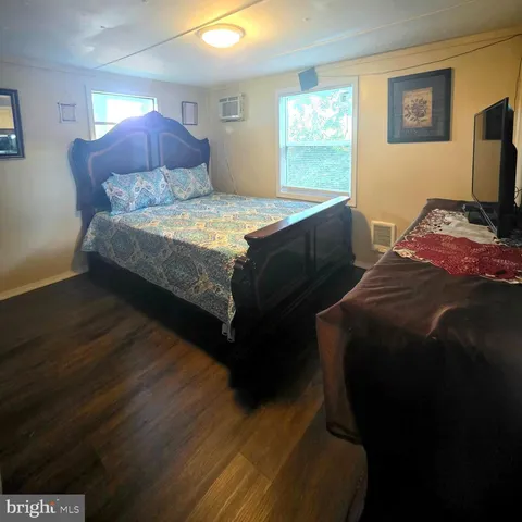 a bedroom with a bed tv and a window