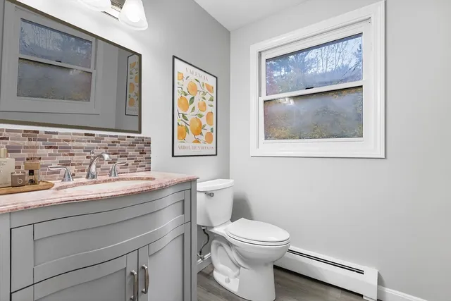 a bathroom with a toilet a sink and mirror