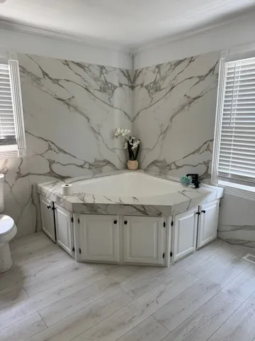 a spacious bathroom with stainless steel appliances granite countertop a sink and cabinets