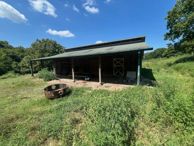 an aerial view of a house with a yard and trees all around