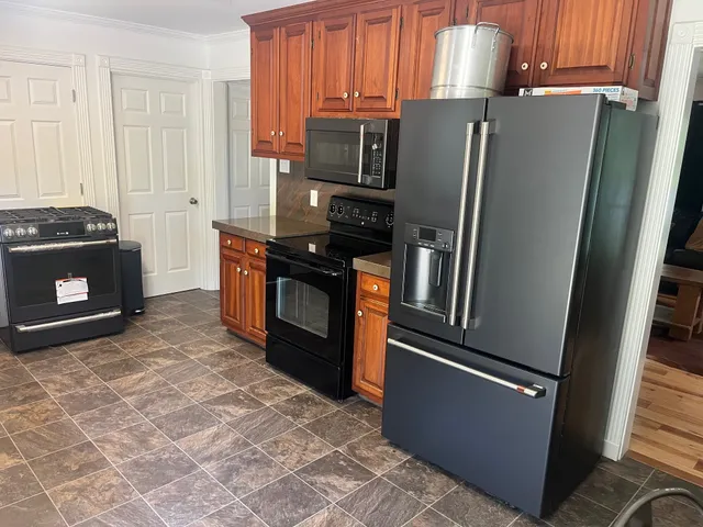 a kitchen with stainless steel appliances granite countertop a refrigerator stove and microwave