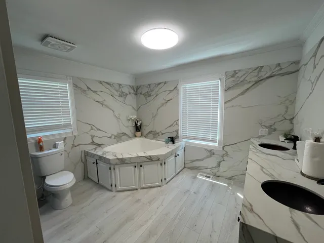 a bathroom with a granite countertop sink a toilet and bathtub