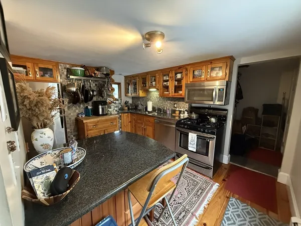 a kitchen with stainless steel appliances granite countertop a stove refrigerator and cabinets