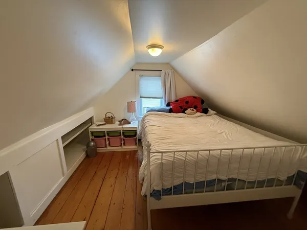 a bed sitting in a bedroom next to a window